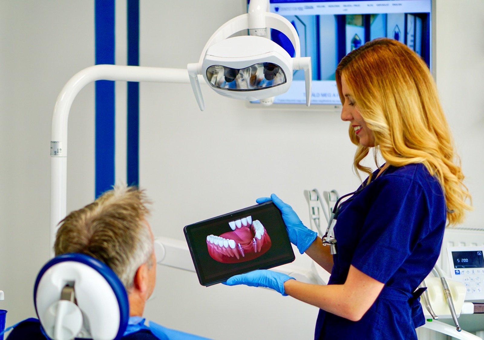Dentist presenting an implant-supported restoration plan to a patient in Budapest